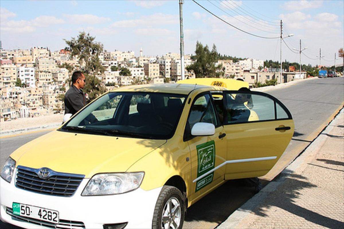 A yellow taxi driving through the streets of Amman